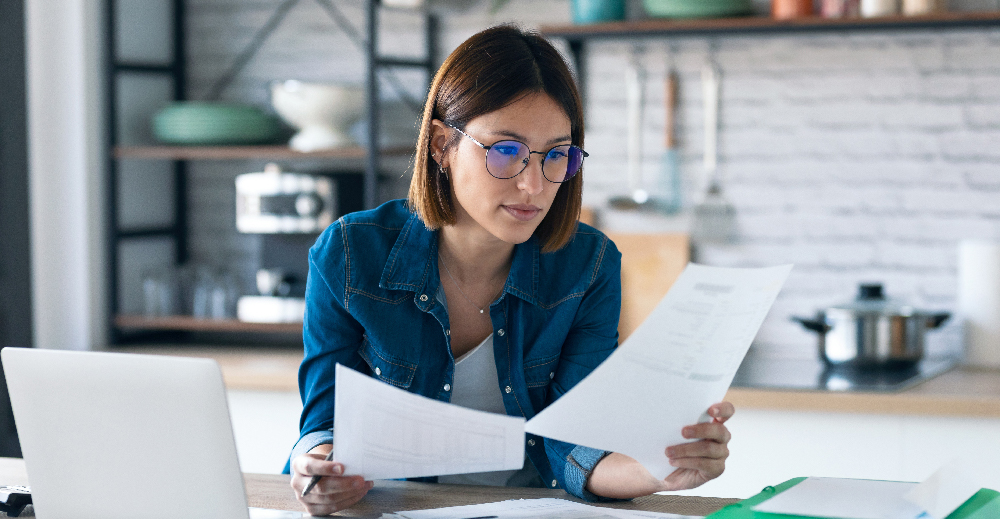 woman with glasses looking at documents